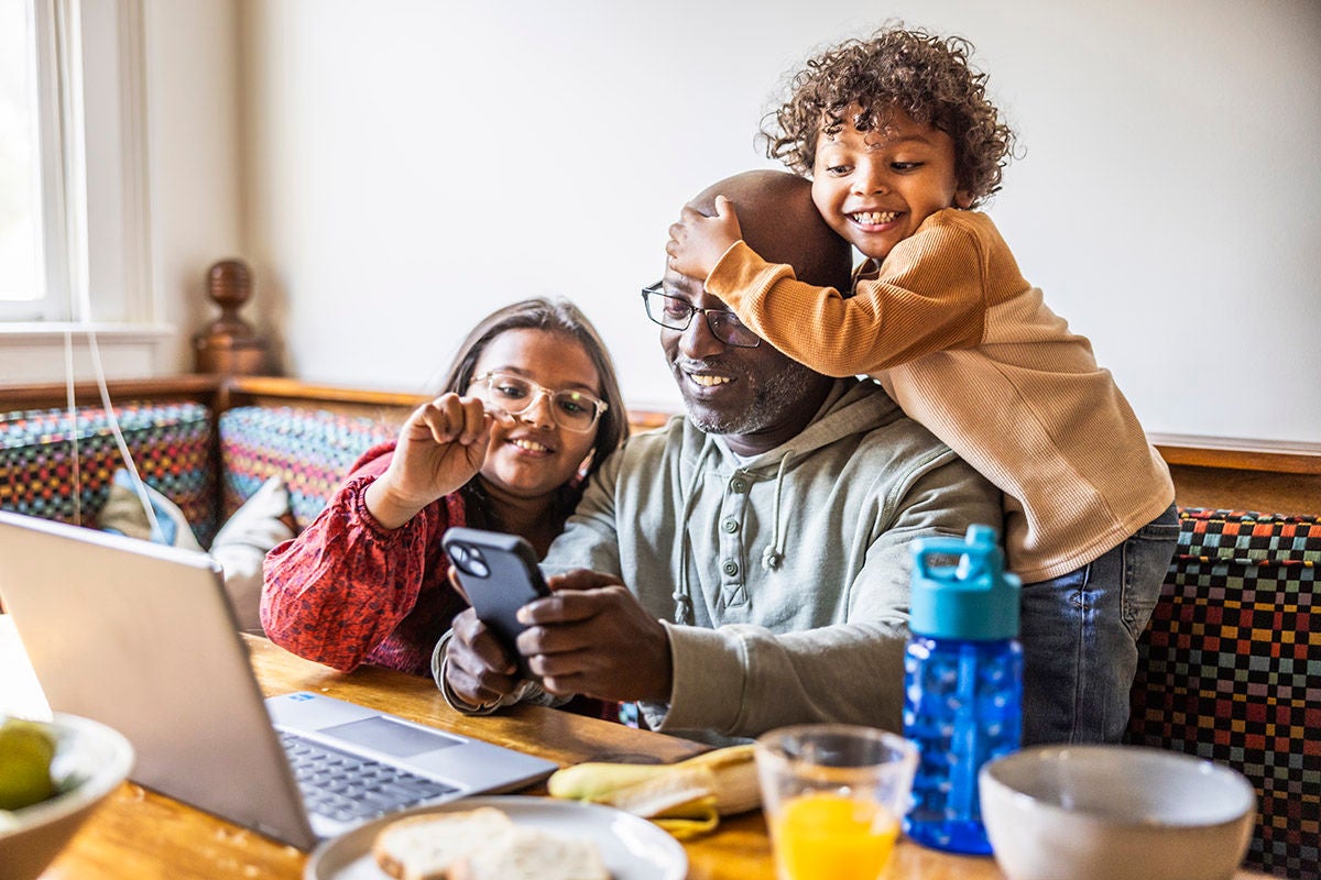 Family managing household finances with online banking on laptop and smartphone at home