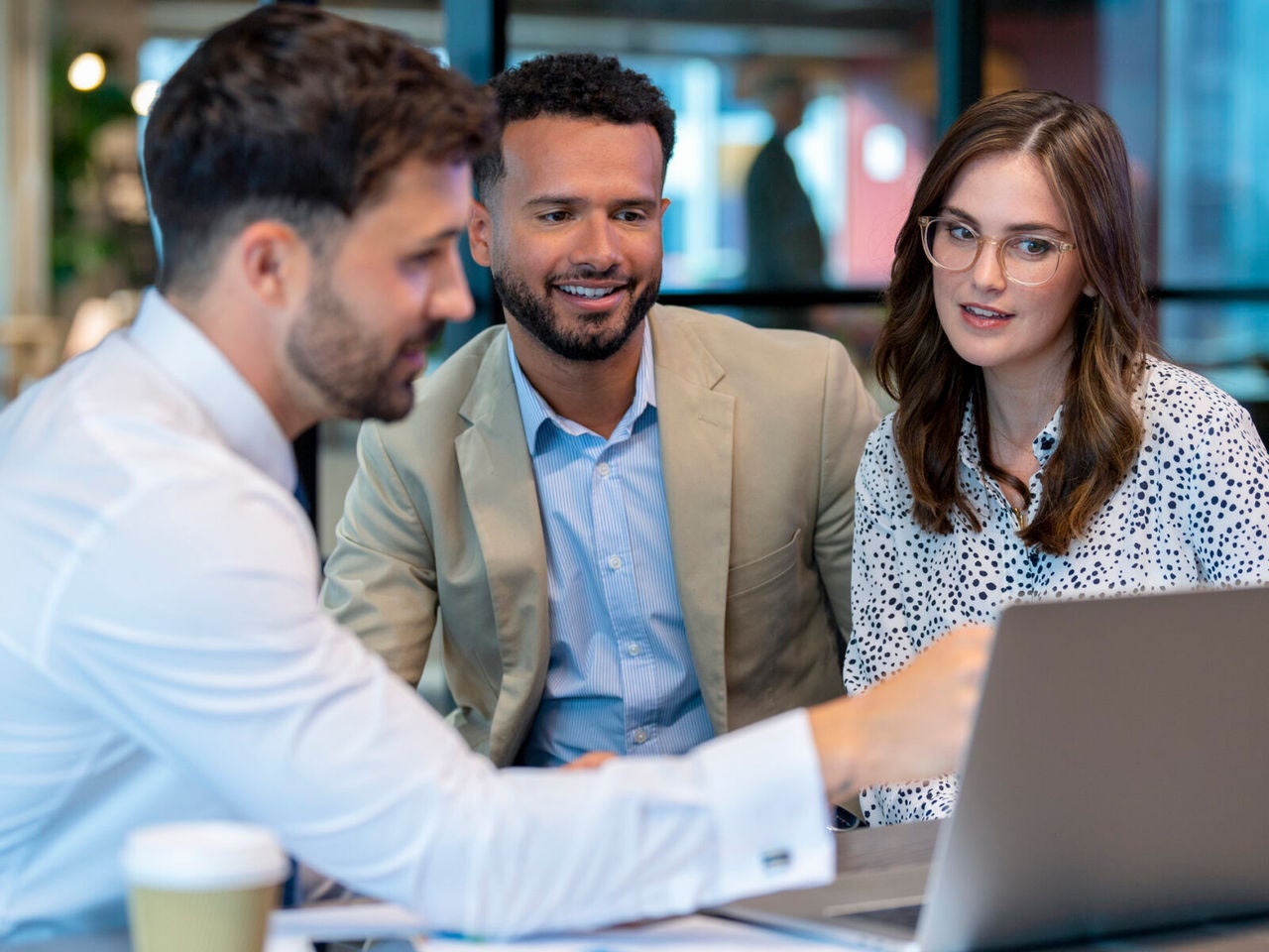 Financial advisor or lawyer with couple explaining options. The agent is using a computer. Couple are well dressed. They sitting in an office and are discussing something with the agent.