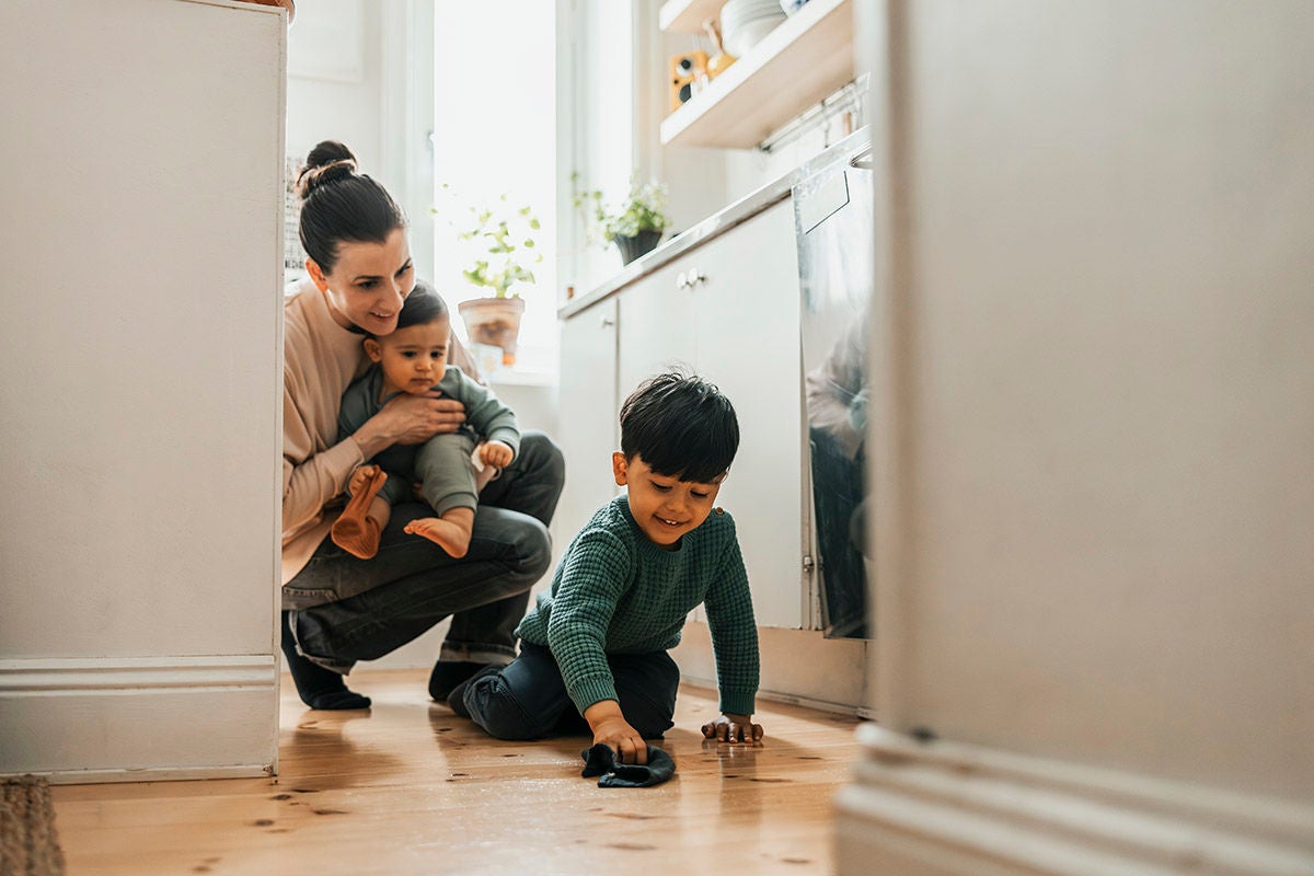 Parent managing household finances while caring for children at home