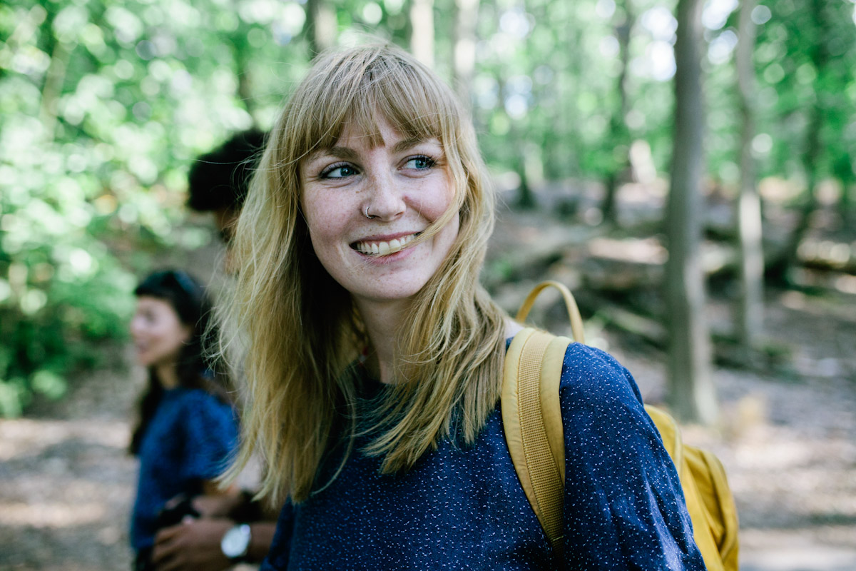 Young woman smiling while hiking outside with friends